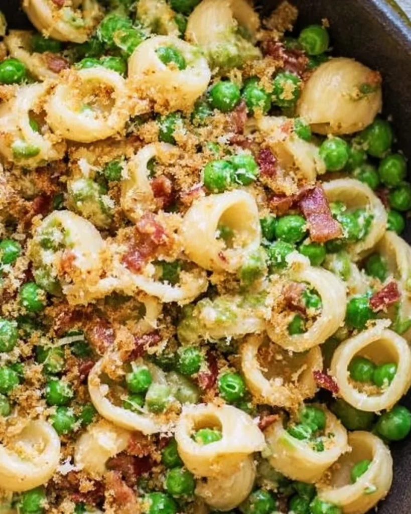 Delicious bowl of Pea Pancetta Pasta topped with fresh peas and crispy pancetta