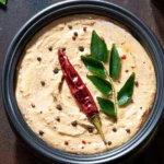A bowl of homemade Peanut Chutney garnished with fresh herbs