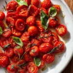 Dish of roasted cherry tomatoes garnished with herbs and spices