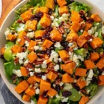 Colorful sweet potato salad with fresh vegetables and dressing