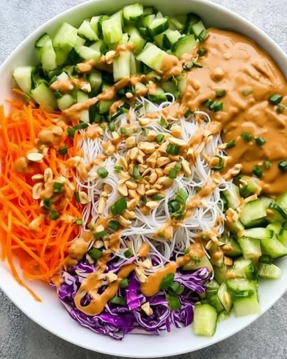 Delicious spring roll bowl topped with peanut sauce and fresh vegetables
