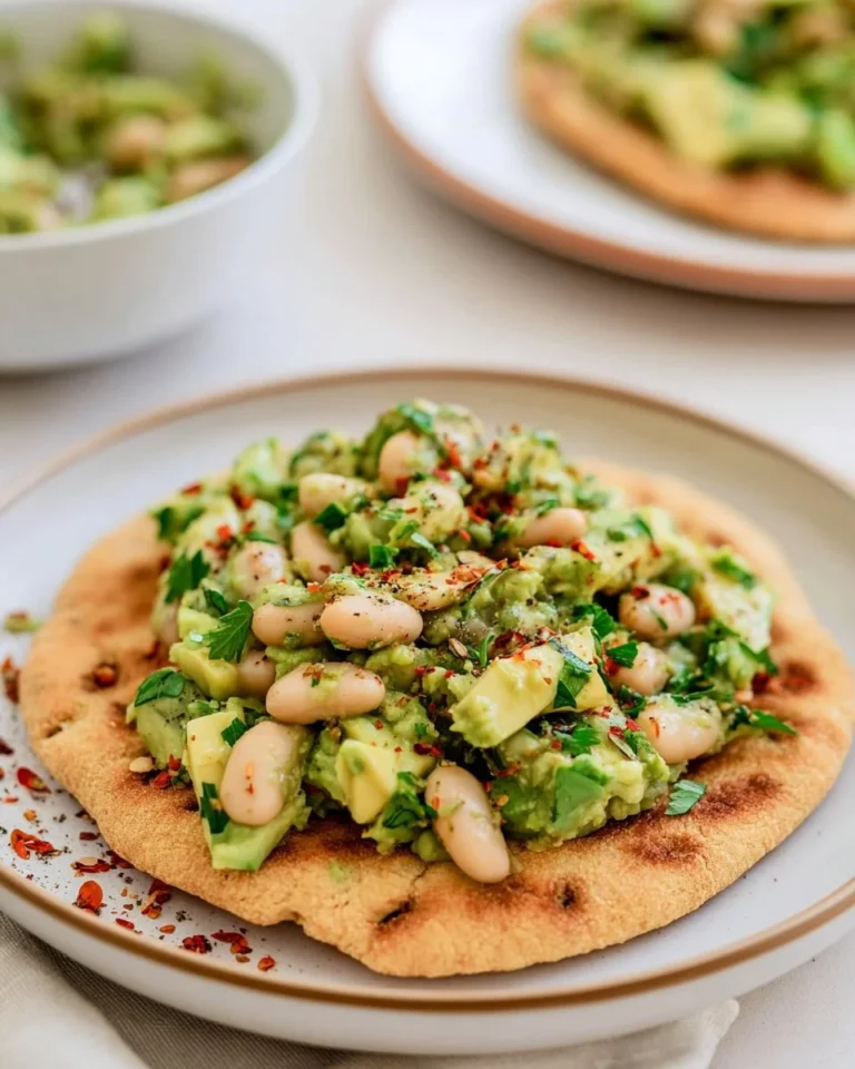 Avocado and pickled bean flatbreads garnished with fresh herbs.