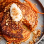 Plate of fluffy carrot oat pancakes topped with syrup and fresh fruit