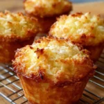Coconut and Pineapple Cottage Cheese Muffins on a rustic wooden table.