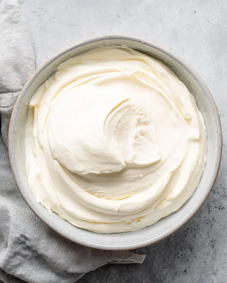 Homemade sour cream in a bowl with a spoon