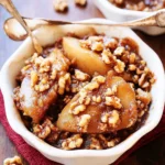 Keto Apple Crisp with Walnuts served in a bowl topped with cream
