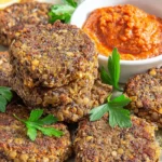 Homemade lentil patties served on a plate with fresh vegetables