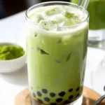 A refreshing cup of matcha milk tea, served hot and iced with vibrant green color.