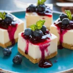 No-bake cheesecake bars with fresh blueberry sauce on a white plate