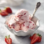 Delicious no-churn strawberry ice cream in a bowl with fresh strawberries