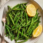 Crispy air fryer green beans served on a plate with herbs