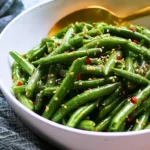 Bowl of vibrant Asian green bean salad with sesame and vegetables