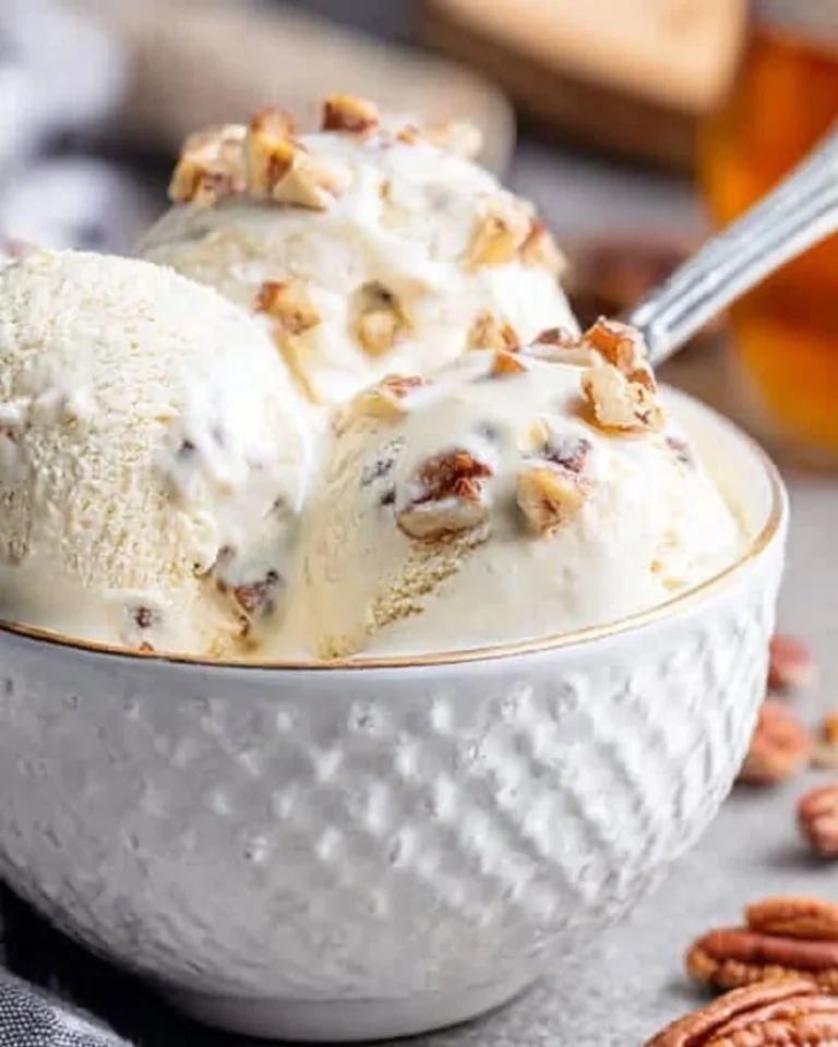 Delicious butter pecan ice cream served in a bowl with pecans on top.