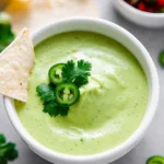 Creamy avocado salsa served in a bowl with tortilla chips
