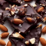 Delicious dark chocolate almond bark with crunchy almonds in a rich chocolate setting.