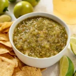 Fresh green tomato salsa served in a bowl with cilantro and lime