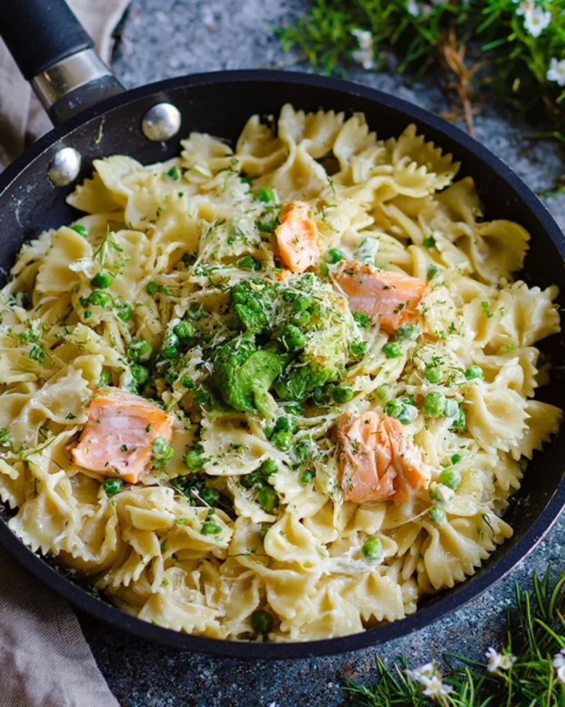 Creamy salmon pasta with crème fraîche garnished with herbs