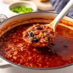 A bowl of vegan stuffed pepper soup with colorful peppers and spices.