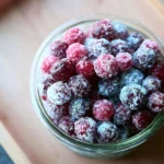 Bowl of 3-ingredient sugared cranberries garnished with mint leaves