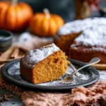A slice of 5-ingredient pumpkin cake topped with cream and spices