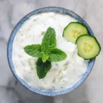 Bowl of Cucumber Raita with chopped cucumbers and spices