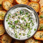A creamy Everything Bagel Dip served with fresh vegetables and crackers.