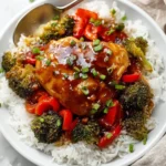 Plate of Honey Garlic Chicken garnished with green onions and sesame seeds