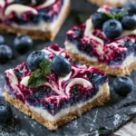 No bake blueberry cheesecake bars topped with fresh blueberries