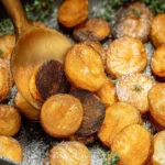 Golden and crispy pan fried potatoes served on a plate.