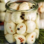 Jar of pickled garlic cloves for cooking and flavoring dishes.
