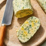 Garlic and herb compound butter spread on a slice of bread